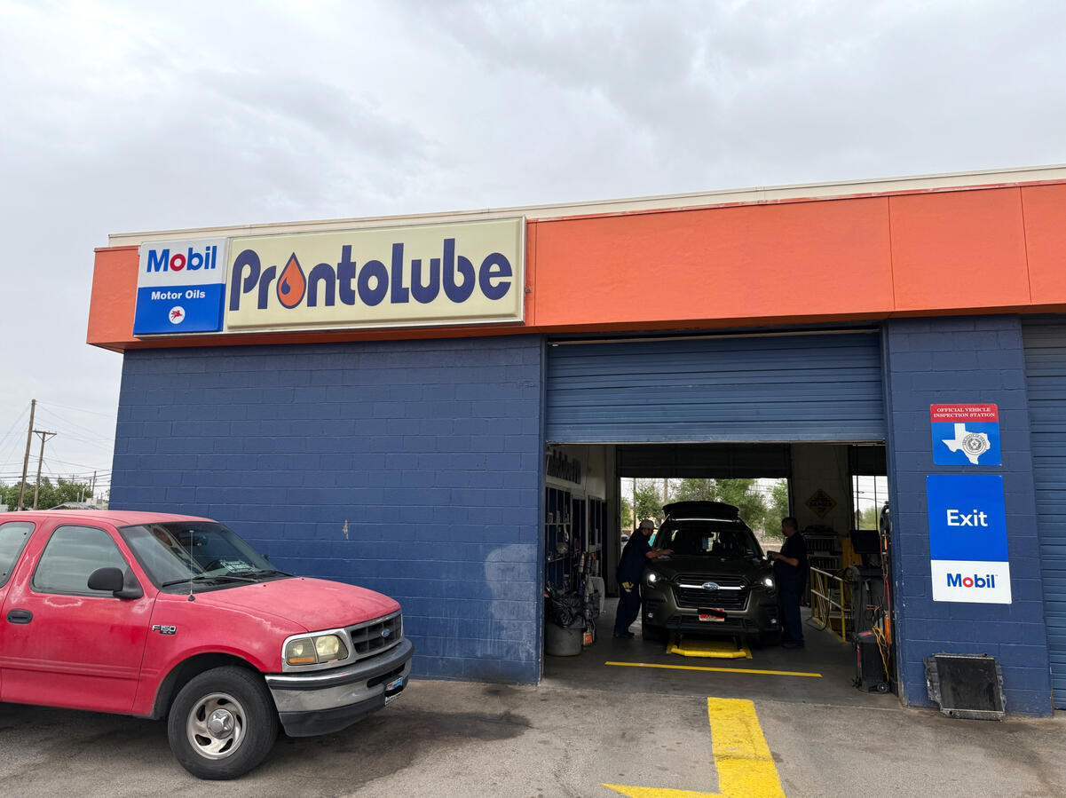 Exterior of J&A Lube auto shop in El Paso, TX with service bays open.